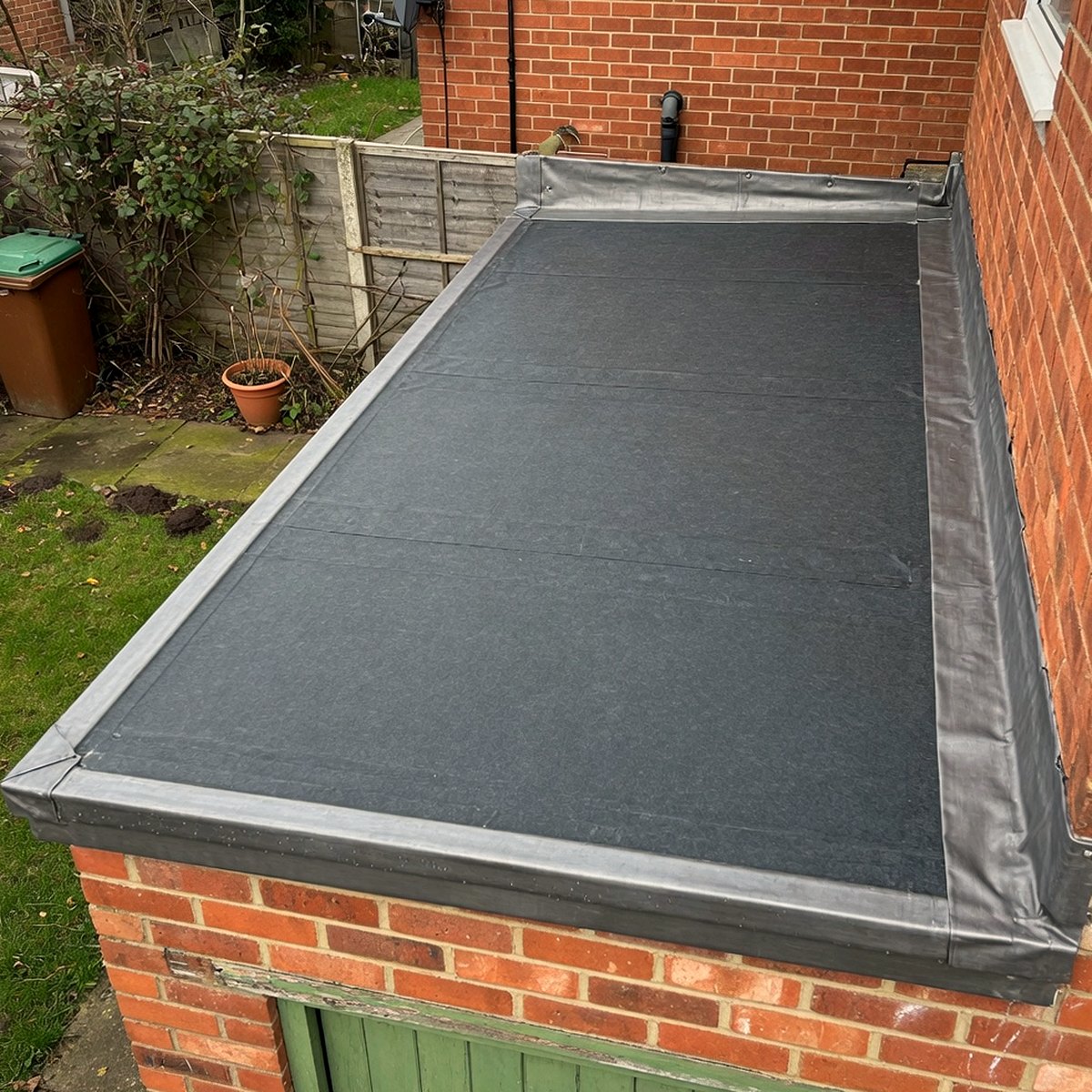 New grey flat felt roof on a British brick garage